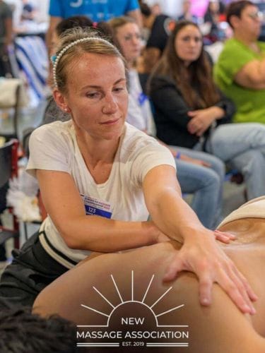 Magda Wasiak-Saczywko wykonująca masaż na mistrzostwach masażu w tle widzowie